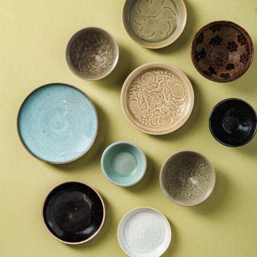 Santos Collection of Early Ceramics - 10 ceramics against a yellow plain background. courtesy of chiswick auctions