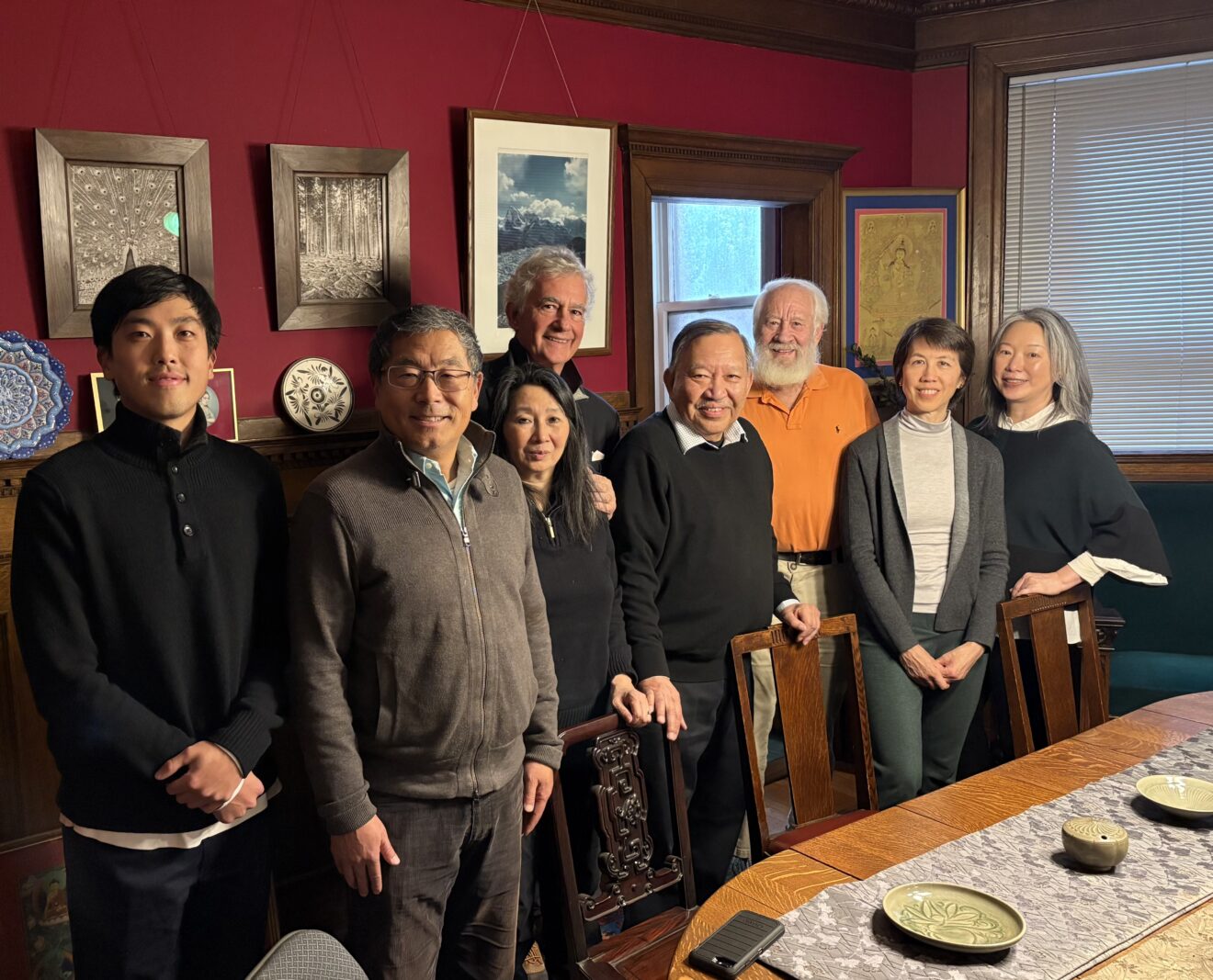 8 ocs members at Brian Salzberg's house standing around a table with ceramic artefacts