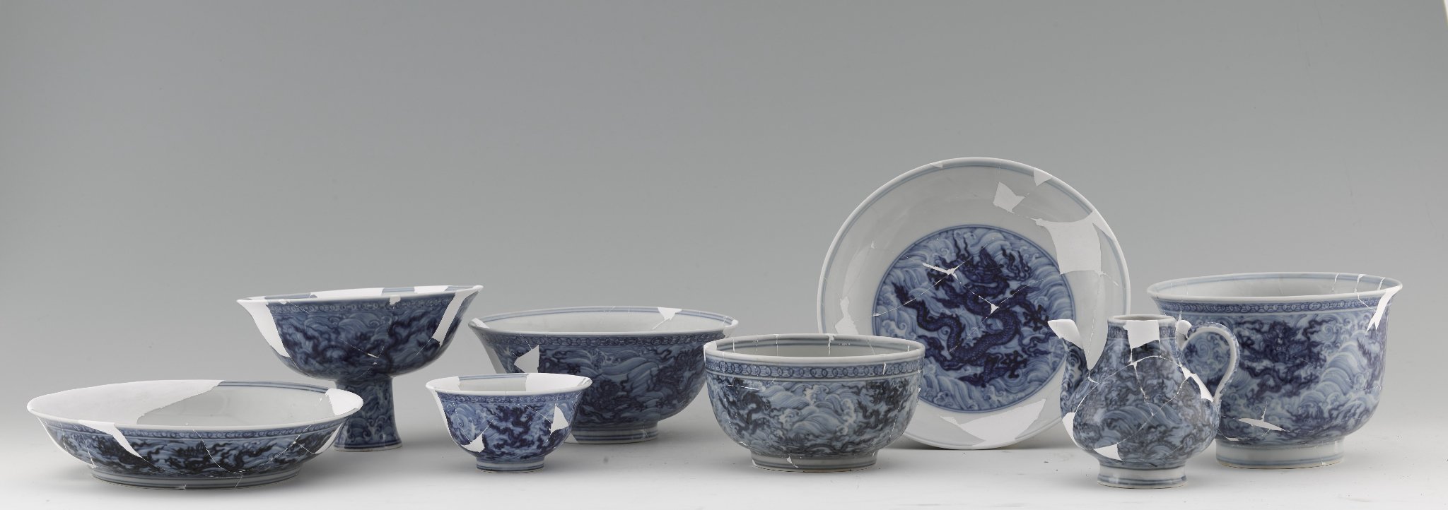 Set of table services with dragons amid waves, excavated from the Imperial Kiln site (2014). Courtesy of the Jingdezhen Imperial Kiln Museum.